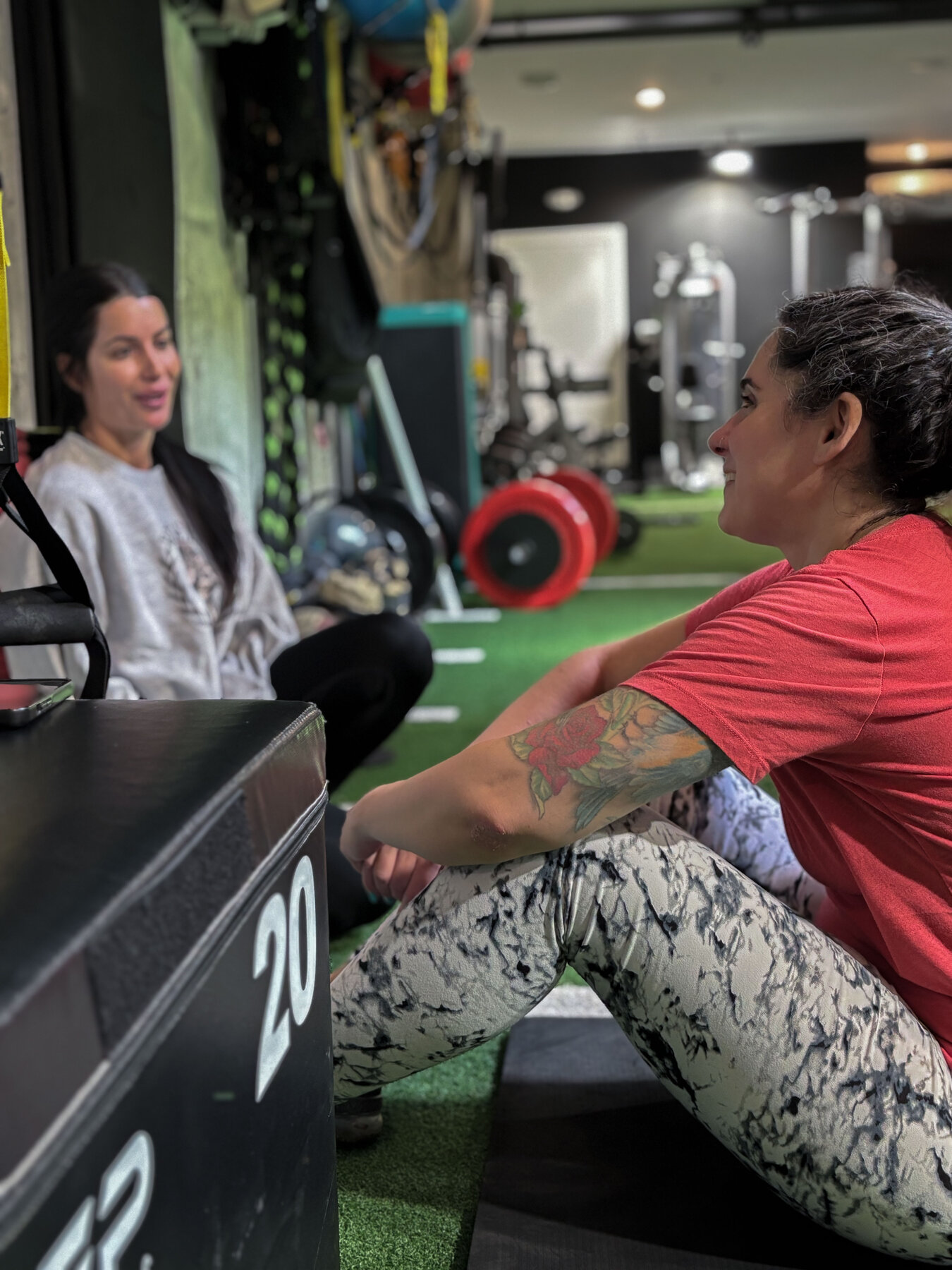 Joe demonstrating leg-press setup to a member at PrideFit