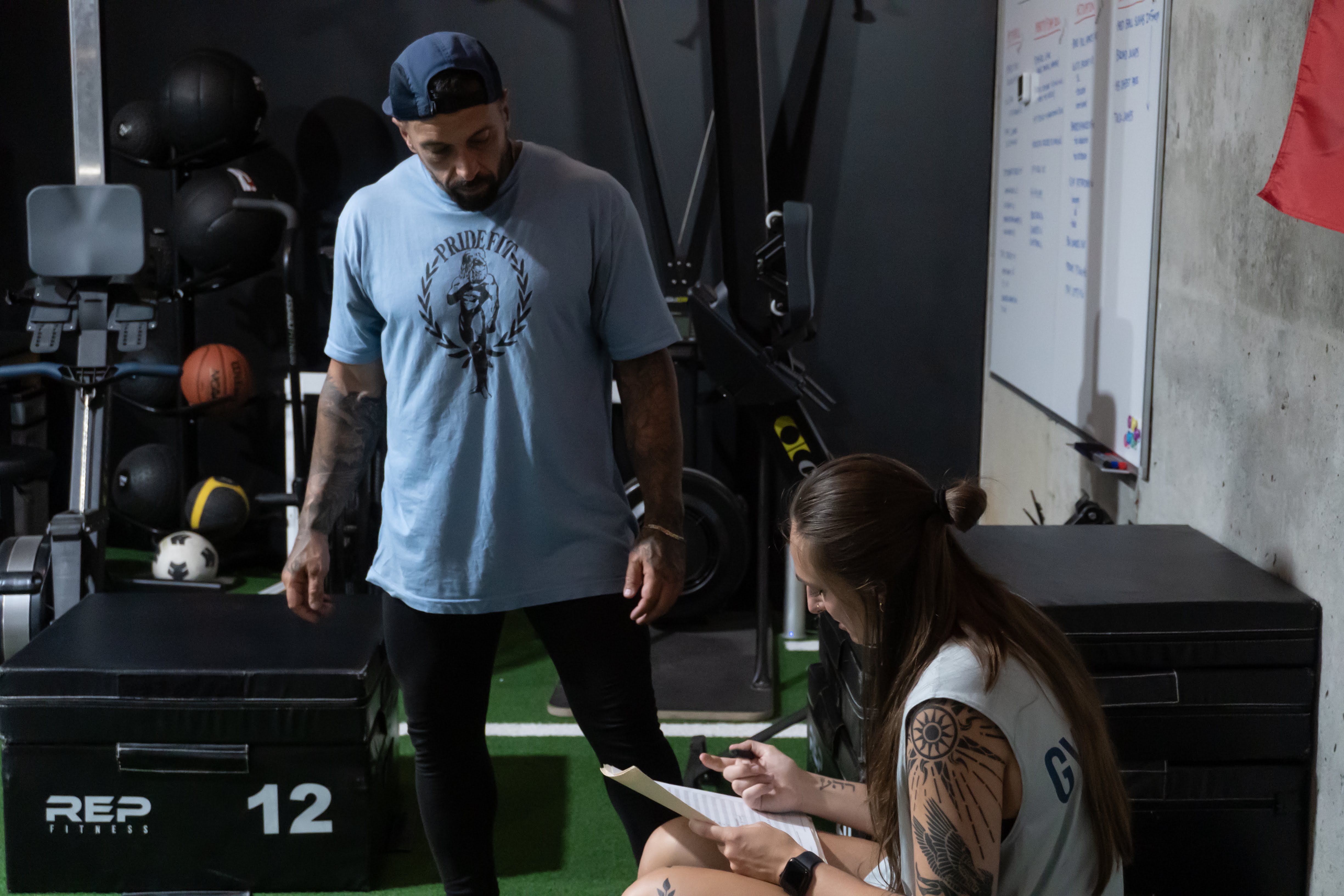Coach reviewing intake and movement notes with a new member