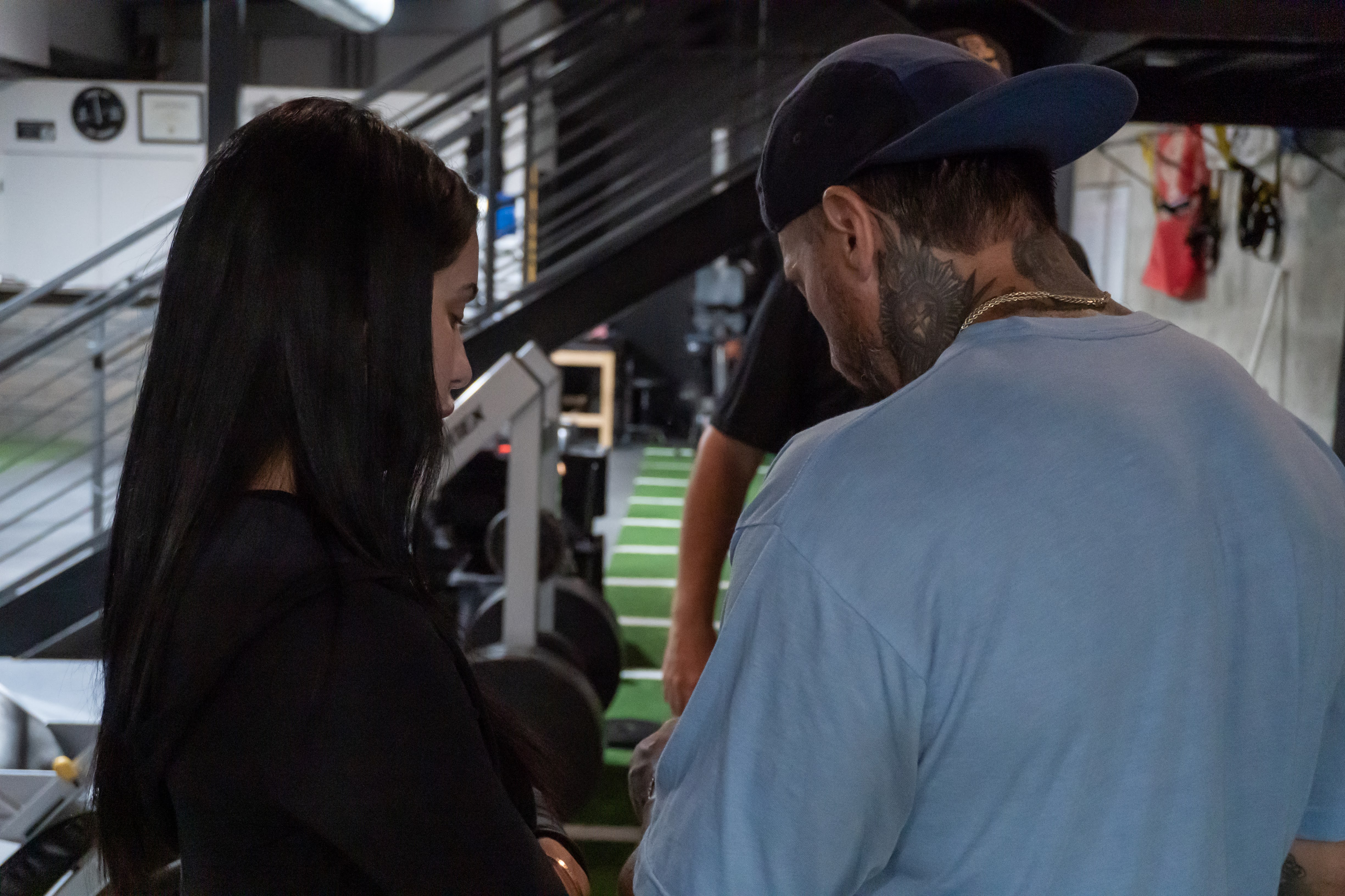 Coach and client having a quiet consultation moment between sets