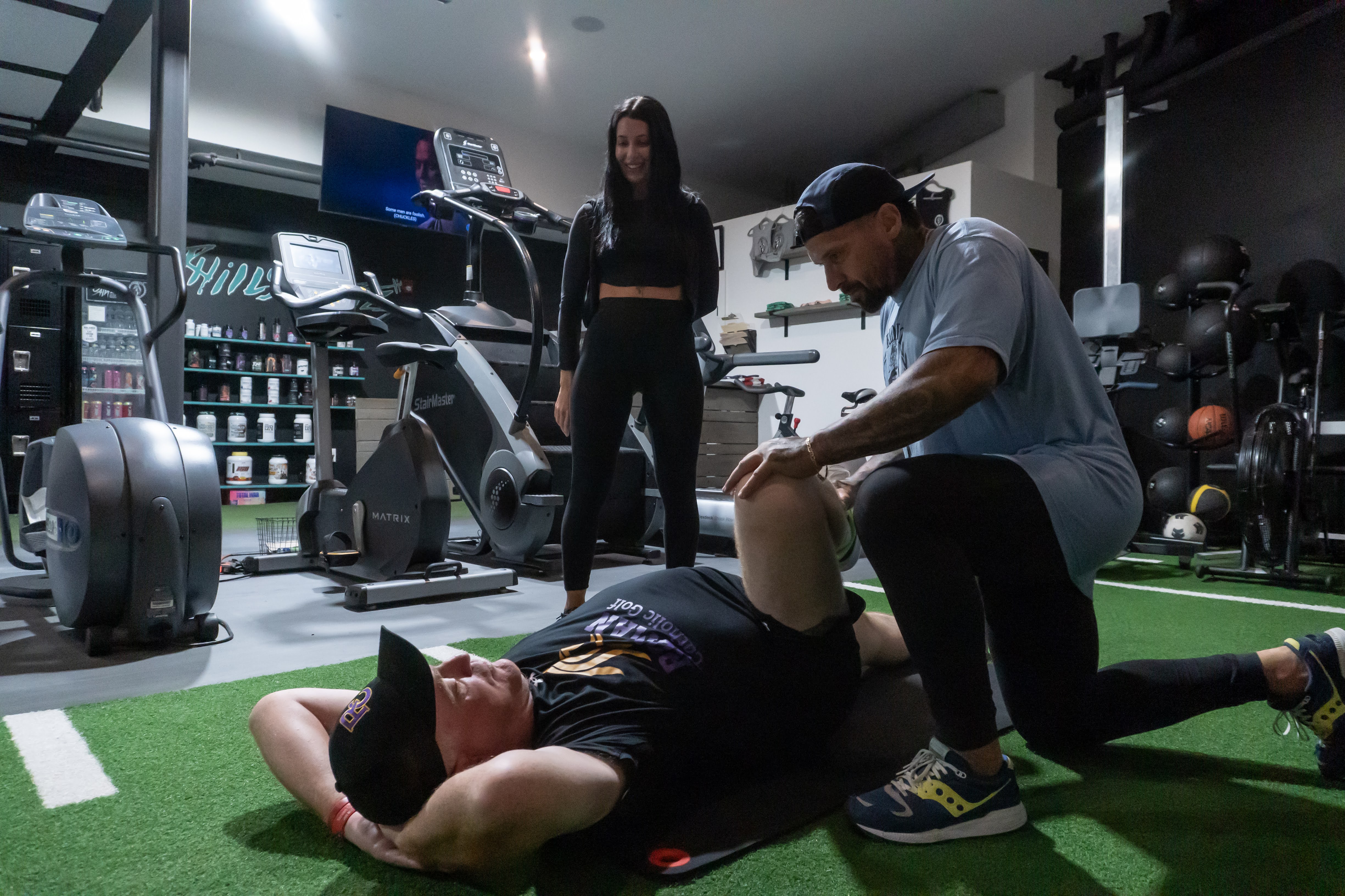 Coach performing a knee mobility assessment on a 1:1 client