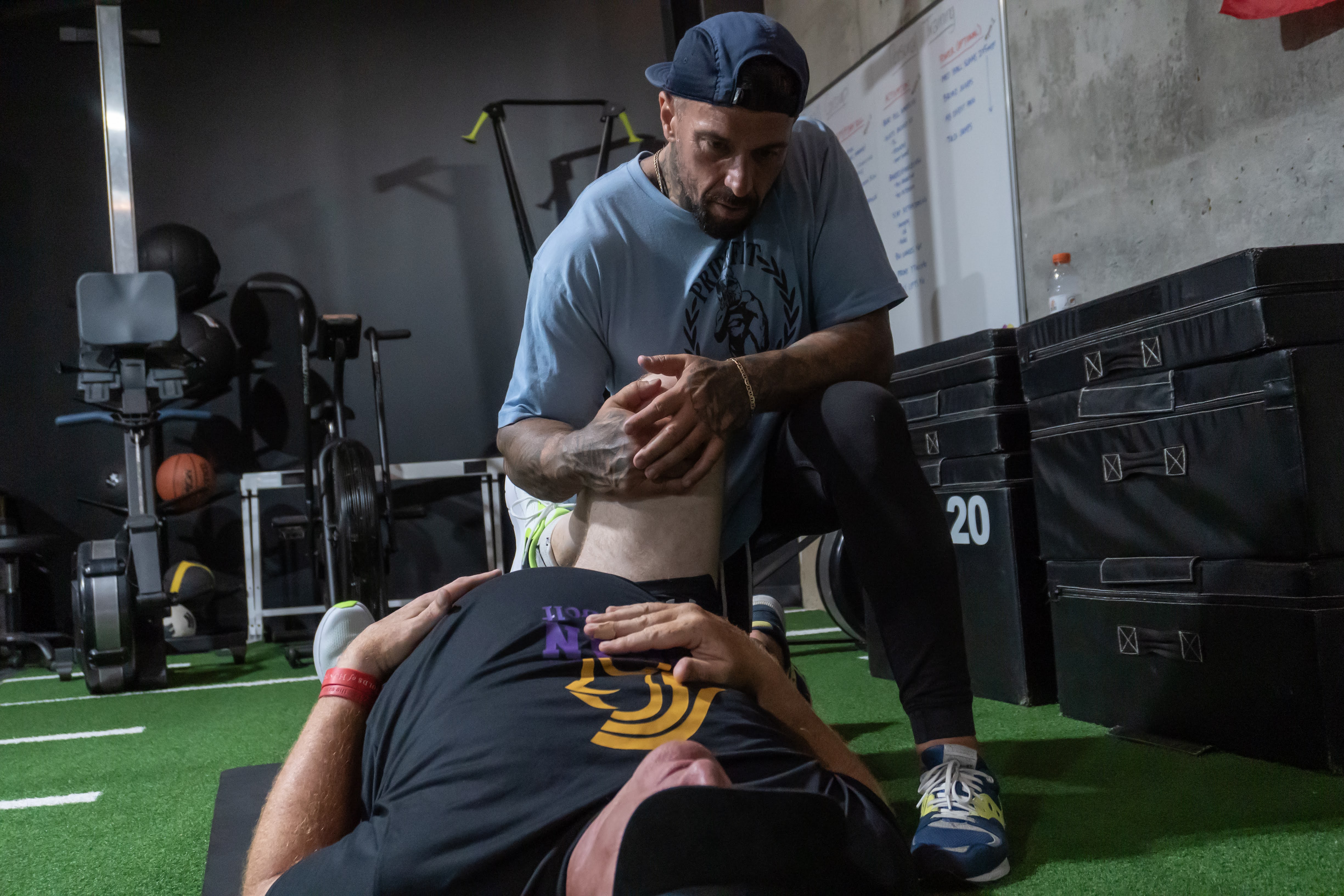 Coach performing a knee mobility assessment on a client